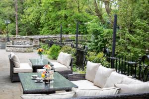 een patio met witte banken en een tafel bij Millbrook Lodge in Lake District National Park