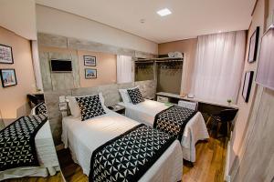 een hotelkamer met 2 bedden en een televisie bij Bristol Viçosa Hotel in Viçosa