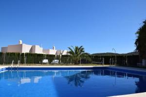 a large blue swimming pool in front of a building at Sunset sea view & garden Spa Cala Tarida 6p max in Cala Tarida