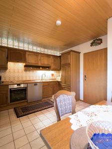 a kitchen with wooden cabinets and a table and a dining room at Ferienwohnung Zum Deichgrafen in Losheim +13 photos