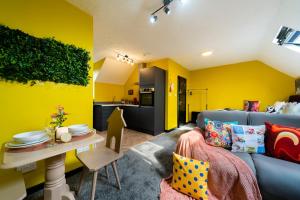 a living room with a blue couch and yellow walls at Jesouth Charming Superb Comfortable Pretty Studio Pad Wifi in Hull