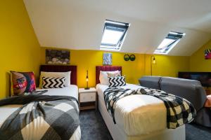 Jesouth Charming Superb Comfortable Pretty Studio Pad Wifi في هال: سريرين في غرفة بجدران صفراء ومنافذ