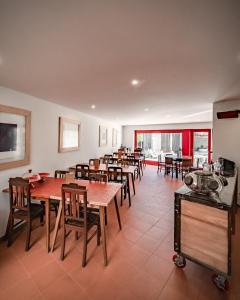 uma sala de jantar com mesas e cadeiras de madeira em Casa da Vrzea - Serra da Estrela em Fornos de Algodres
