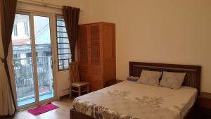 a bedroom with a bed and a large window at Best Price Hồ Gươm Apartments for Long Stay in Hanoi