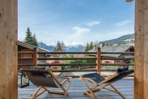 a chair on a deck with a view of a mountain at Chalet Melilot in Verbier