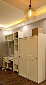 Zimmer mit einem weißen Schreibtisch und einem Kühlschrank. in der Unterkunft Elite Corner Apartment in Ţāb Kirā‘
