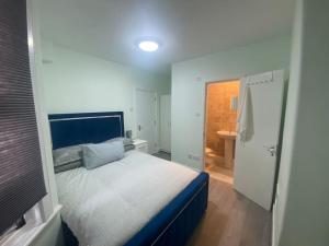 a small bedroom with a bed and a bathroom at MBA COSY 4 bedroom house in Leavesden Green