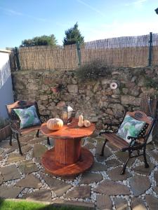 a wooden table and chairs on a stone patio at CASA O QUINTEIRO in Vimianzo