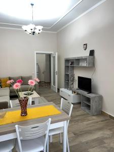 a living room with a dining room table and a couch at Ani Apartament in Durrës