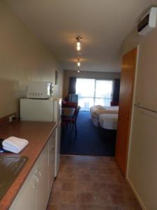 een hotelkamer met een keuken en een slaapkamer bij Wakatipu View Apartments in Queenstown