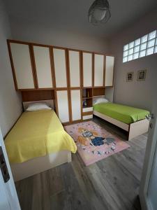 Un dormitorio con dos camas y una alfombra. en Ani Apartament, en Durrës