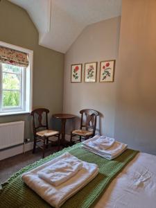 um quarto com duas toalhas numa cama e duas cadeiras em The Three Horseshoes East Worldham em Alton