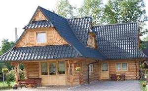 une cabane en rondins avec un toit noir dans l'établissement Domki i pokoje Toporówka, à Zakopane