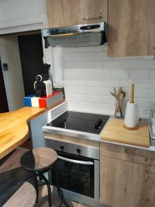 a small kitchen with a stove and a stool at LE QUAI in Port-la-Nouvelle