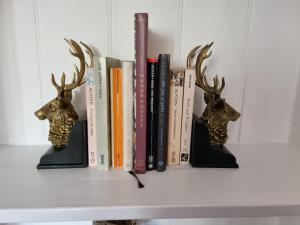 a shelf with books and deer heads on it at The Three Horseshoes East Worldham in Alton