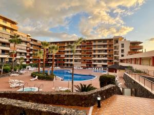 an apartment complex with a swimming pool and a resort at Gecko apartman in Puerto de Santiago