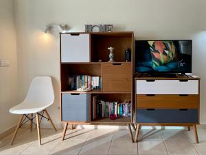 a entertainment center with a tv and a book shelf at Gecko apartman in Puerto de Santiago