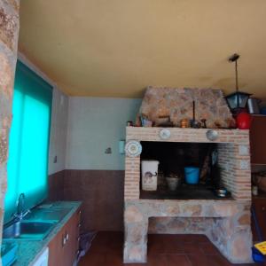 una cucina con camino in mattoni in una stanza di Cortijo del Cuco a Riópar