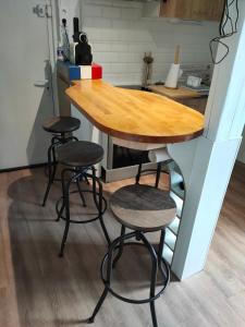 a kitchen with a wooden table and four stools at LE QUAI in Port-la-Nouvelle