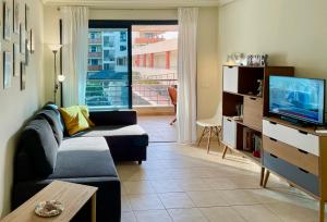 a living room with a couch and a tv at Gecko apartman in Puerto de Santiago