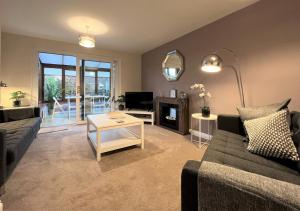 a living room with a couch and a table at Spacious Townhouse with Parking in Telford