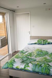 Un dormitorio con una cama con una huella tropical. en Bluebell Cabin, en Badsey