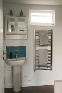 ein Bad mit einem Waschbecken und einem Spiegel in der Unterkunft Bluebell Cabin in Badsey