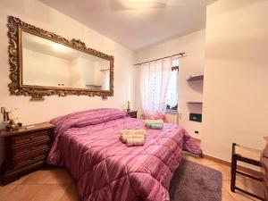 una camera con letto rosa e specchio di Relax apartament - Besolagno GE 