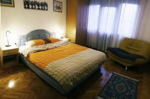 a bedroom with a bed and a chair in it at Centre Point Apartment in Podgorica