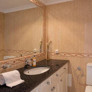 a bathroom with a sink and a mirror at Apartment Kairi in Vale do Lobo +8 photos