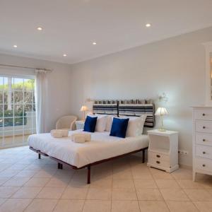 a large bedroom with a large bed with blue pillows at Apartment Kairi in Vale do Lobo