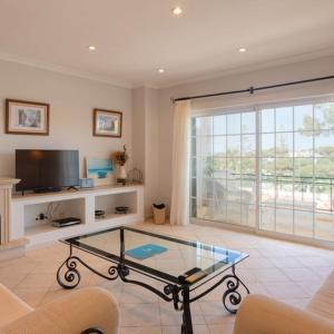 Apartment Kairi في فالي دو لوبو: غرفة معيشة مع طاولة زجاجية وتلفزيون +8 صور