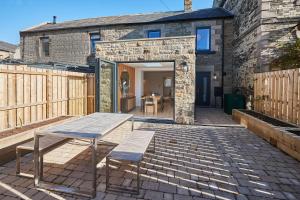 a patio with a table and benches in front of a building at Host & Stay - Taylor Street in Seahouses