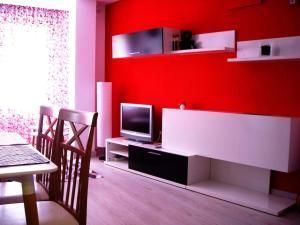 Elle comprend un salon doté d'un mur rouge et d'une télévision. dans l'établissement El Vinilo. Aparcamiento exterior gratuito, à Teruel
