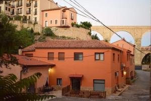 une maison orange sur le côté d'une colline avec des bâtiments dans l'établissement El Vinilo. Aparcamiento exterior gratuito, à Teruel