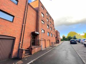 eine leere Straße neben einem roten Backsteingebäude in der Unterkunft Anniesland Glasgow 1bd Flat - Free Parking in Glasgow