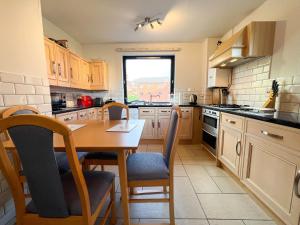 a kitchen with a wooden table and chairs in it at Anniesland Glasgow 1bd Flat - Free Parking in Glasgow