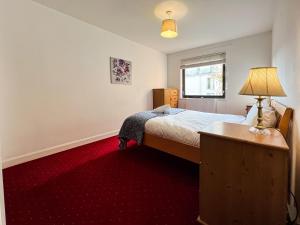 een slaapkamer met een bed en een rode loper bij Anniesland Glasgow 1bd Flat - Free Parking in Glasgow