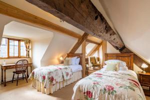 a attic bedroom with two beds and a chair at The Town House Ludlow in Ludlow