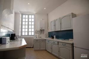 a kitchen with white cabinets and a large window at Hyper centre - 3 chambres - Gare - wifi - cosy in Bourg-en-Bresse