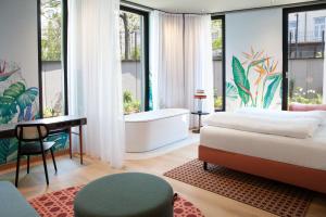 una camera con vasca, letto e scrivania di Hotel Indigo Vienna - Naschmarkt, an IHG Hotel a Vienna