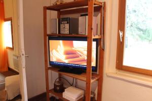 - une télévision sur une étagère en bois dans l'établissement La Pyrène Maison de vacances, à Ore