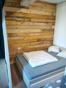 a bed in a room with a wooden wall at LE QUAI in Port-la-Nouvelle