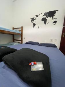 - une chambre avec un lit et une carte du monde sur le mur dans l'établissement Pousada Ocean - Beira Mar, à Bertioga
