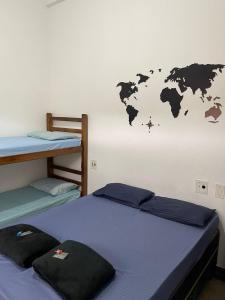2 Betten in einem Zimmer mit einem Wandbild in der Unterkunft Pousada Ocean - Beira Mar in Bertioga