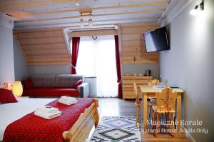 a room with a bed and a table and a couch at Magiczne Korale - Kameralne miejsce na odpoczynek dla Dorosłych - Adult Only in Kościelisko