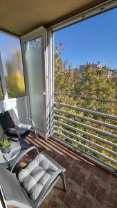 einen Balkon mit einem Stuhl und einem großen Fenster in der Unterkunft Laura Exclusive, dizajnerski uređen stan, izvrsno opremljen in Vinkovci