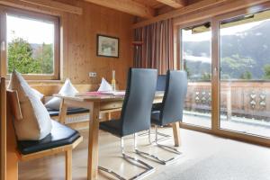 ein Esszimmer mit einem Tisch, Stühlen und Fenstern in der Unterkunft Ferienhaus Oetztal in Sautens