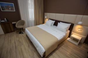 a bedroom with a large bed and a chair at History Hotel Tbilisi in Tbilisi City