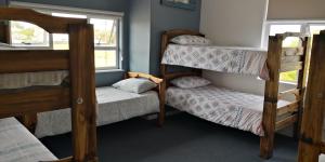 a room with three bunk beds and a window at Hermanus Backpackers & Budget Accommodation in Hermanus